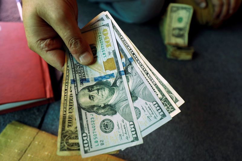 © Reuters. FILE PHOTO: A trader shows U.S. dollar notes at a currency exchange booth in Peshawar, Pakistan December 3, 2018. REUTERS/Fayaz Aziz/File Photo