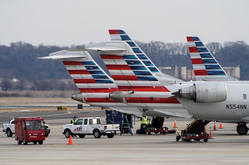 © Reuters. FILE PHOTO: Grounds crews work around American Airlines aircraft at Reagan National Airport in Arlington, Virginia, U.S., January 24, 2022.   REUTERS/Joshua Roberts/File Photo