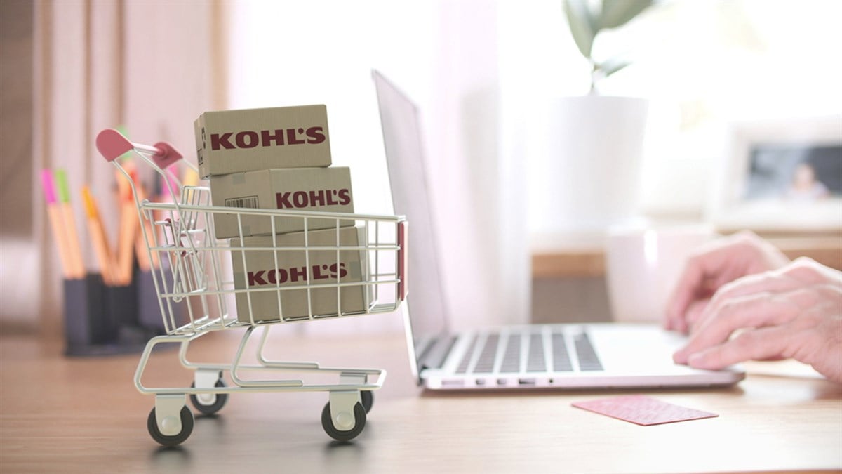 Cartons with KOHLS logo in shopping trolley near laptop. Editorial online store order related 3D rendering