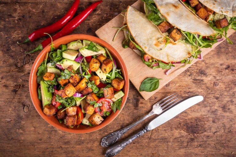 Vegetable salad with fried tofu in a bowl and vegan tacos with waxes, tofu and hot peppers, top view - vegetarian cuisine