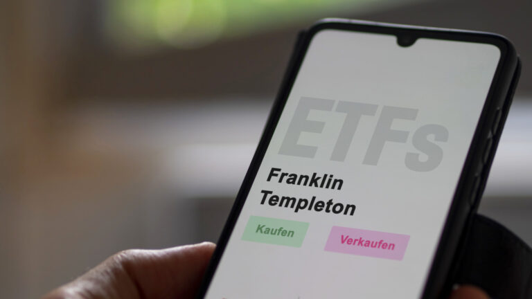 An investor's analyzing the Franklin Templeton etf fund on screen. A phone shows the ETF's prices Franklin Templeton to invest. German text.