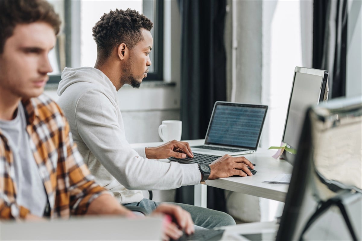 Selective focus of two multicultural programmers working together in office - stock image