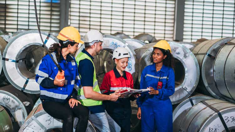 Team engineers and foreman checking the machinery in detail at factory machines. Worker industry join hand for collaboration.