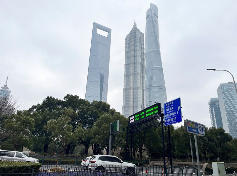© Reuters. FILE PHOTO: Cars travel past a display showing Shanghai and Shenzhen stock indexes near the Shanghai Tower and other skyscrapers at the Lujiazui financial district in Shanghai, China February 5, 2024. REUTERS/Xihao Jiang/File Photo © Reuters. FILE PHOTO: Cars travel past a display showing Shanghai and Shenzhen stock indexes near the Shanghai Tower and other skyscrapers at the Lujiazui financial district in Shanghai, China February 5, 2024. REUTERS/Xihao Jiang/File Photo
