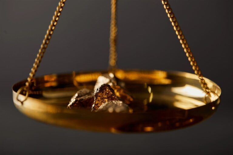 Selective focus of golden stones on scales on dark background — Photo