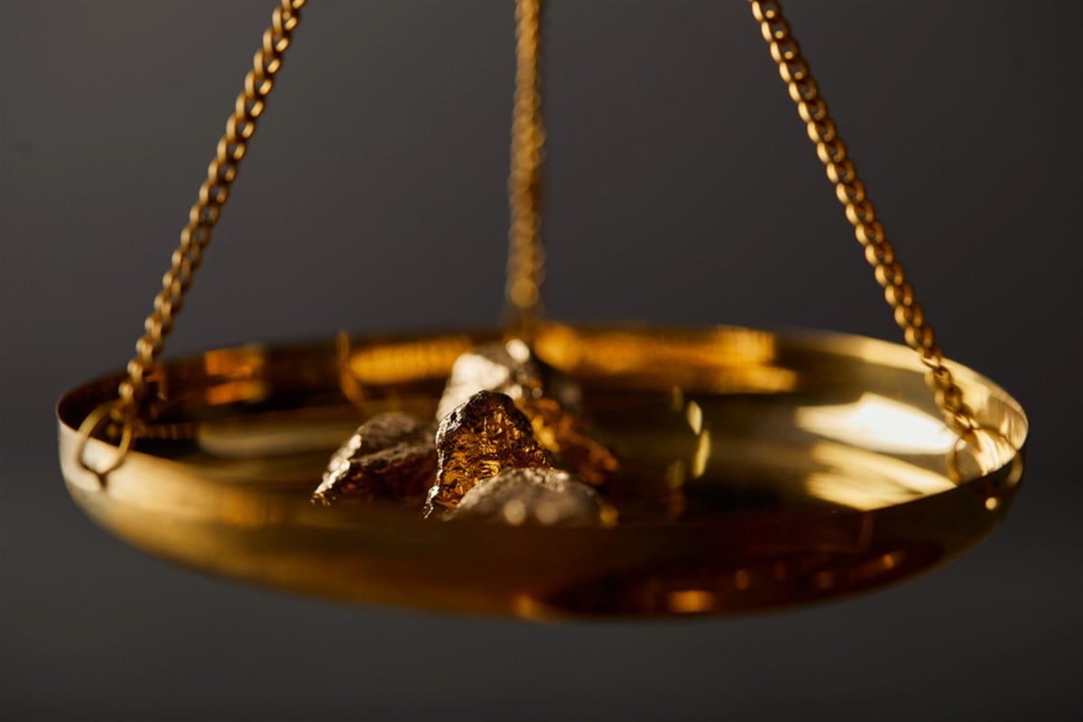 Selective focus of golden stones on scales on dark background — Photo