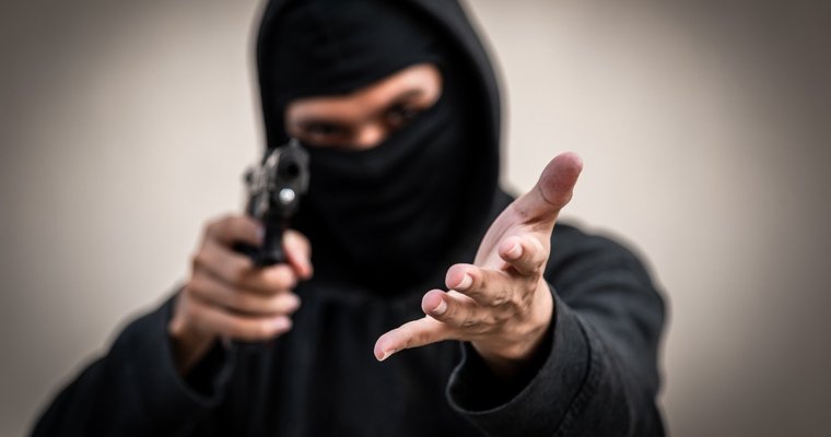 Robber pointing gun and demanding money