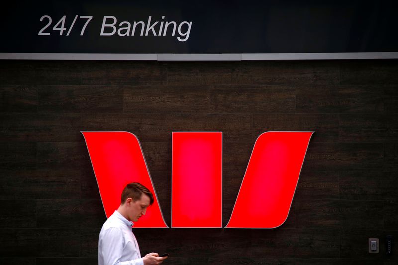 © Reuters. A pedestrian looks at his phone as he walks past a logo for Australia's Westpac Banking Corp located outside a branch in central Sydney, Australia, November 5, 2018.   REUTERS/David Gray/File Photo