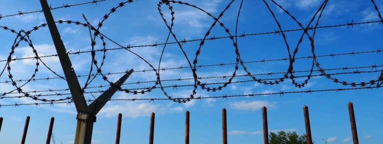 Barbed wire against blue sky