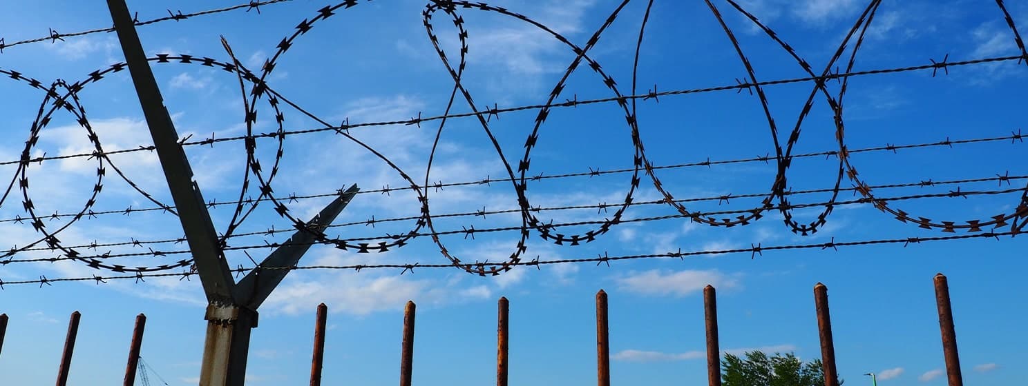 Barbed wire against blue sky