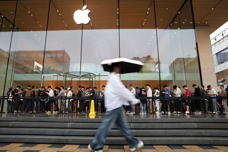 © Reuters. People line up outside an Apple store on a rainy day as the new iPhone 16 series smartphones go on sale, in Beijing, China September 20, 2024. REUTERS/Florence Lo/File Photo