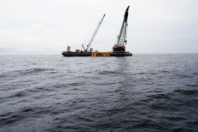 © Reuters. FILE PHOTO: A crane hangs over the first jacket support structure installed to support a turbine for a wind farm in the waters of the Atlantic Ocean off Block Island, Rhode Island July 27, 2015. REUTERS/Brian Snyder/File Photo