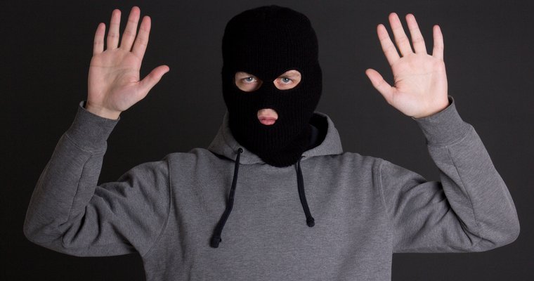 masked thief with hands up