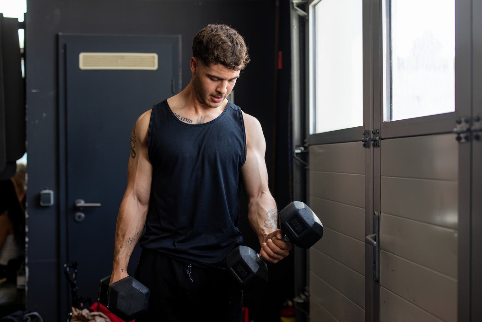 Focused athlete lifting dumbbells in gym