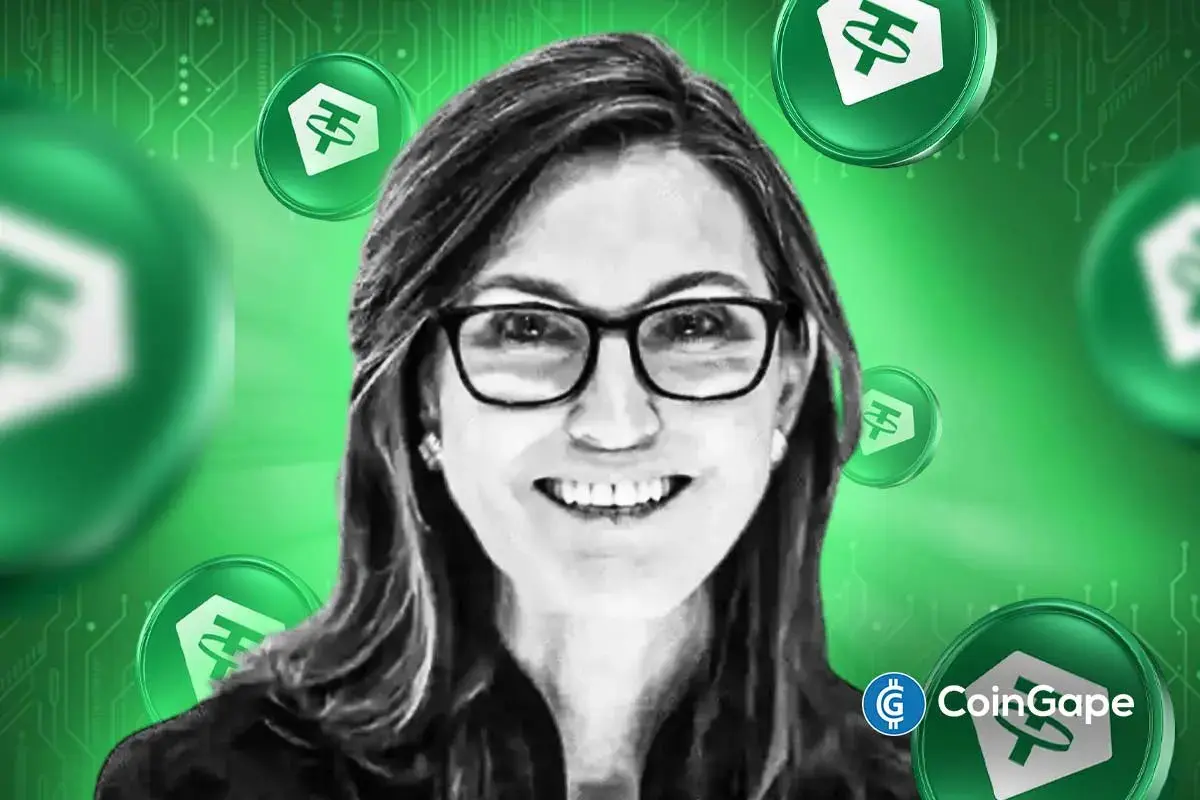 Cathie Wood with Tether logos in background, symbolizing Ark Invest’s interest.