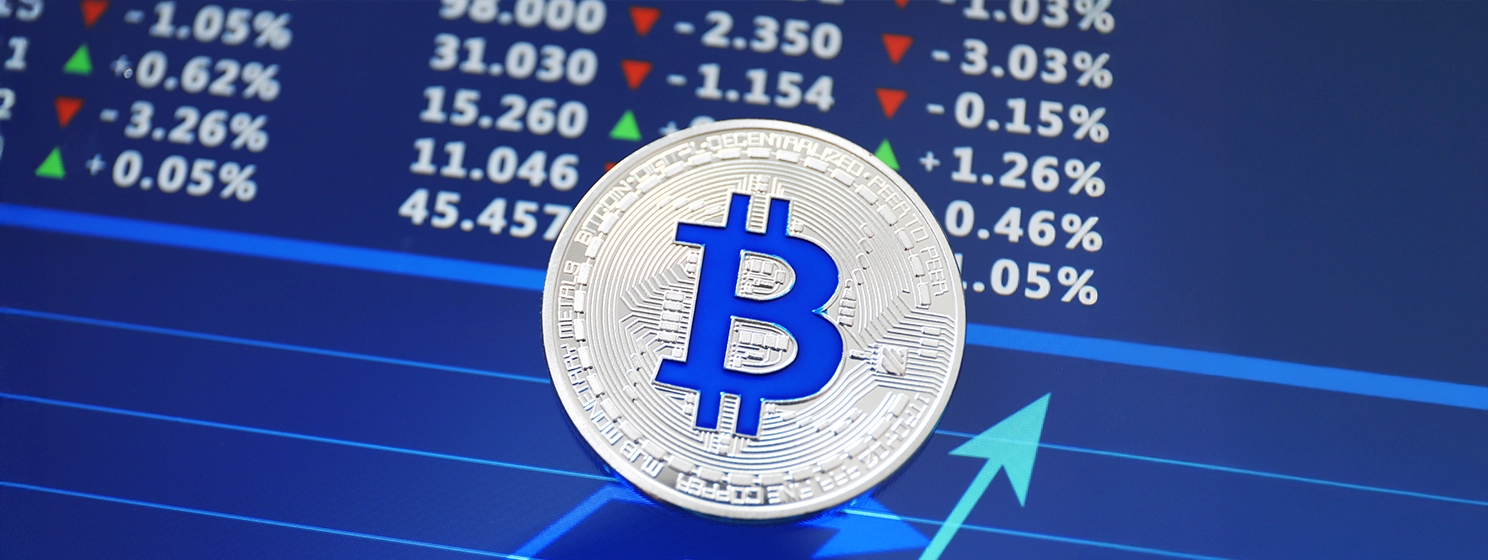 Silver bitcoin on screen with chart.