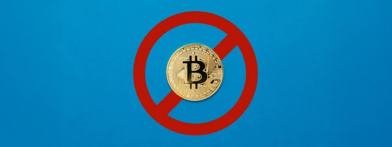 A physical Bitcoin coin centered within a red prohibition sign on a blue background.