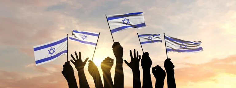 Silhouette of arms raised waving an Israel