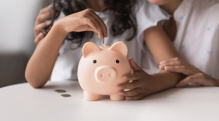 Little girl put coin into piggy bank, caring of family budget with mother